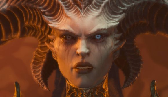 A demonic woman with one blue eye and one green looks angrily into the camera, twisting horns protruding from her head